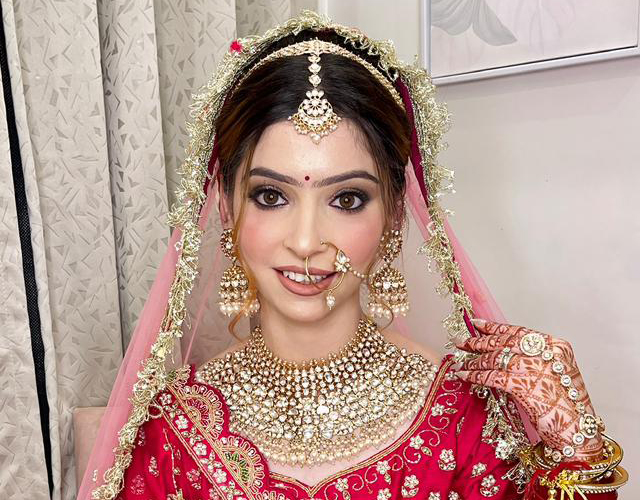 Traditional Indian bridal makeup by Nithika Aroraa featuring flawless complexion, bridal jewelry, and wedding-ready glam.