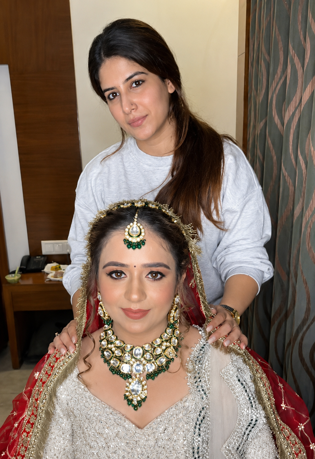 Nithika Aroraa, professional bridal makeup artist, posing with a bride after completing a glamorous bridal makeup transformation.